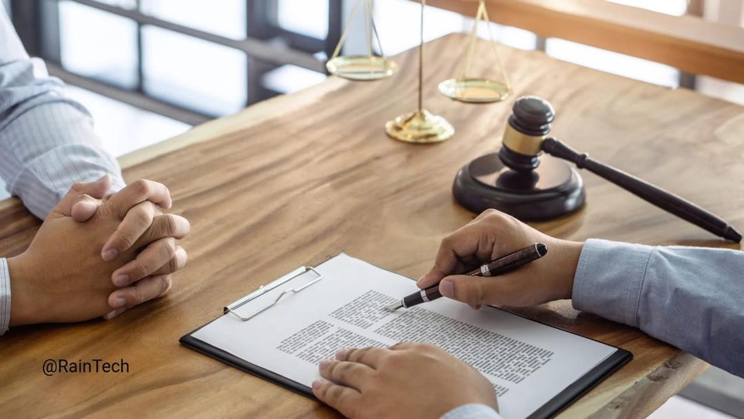 Hands reviewing a legal document with a gavel and scales of justice, illustrating EOR contract compliance.
