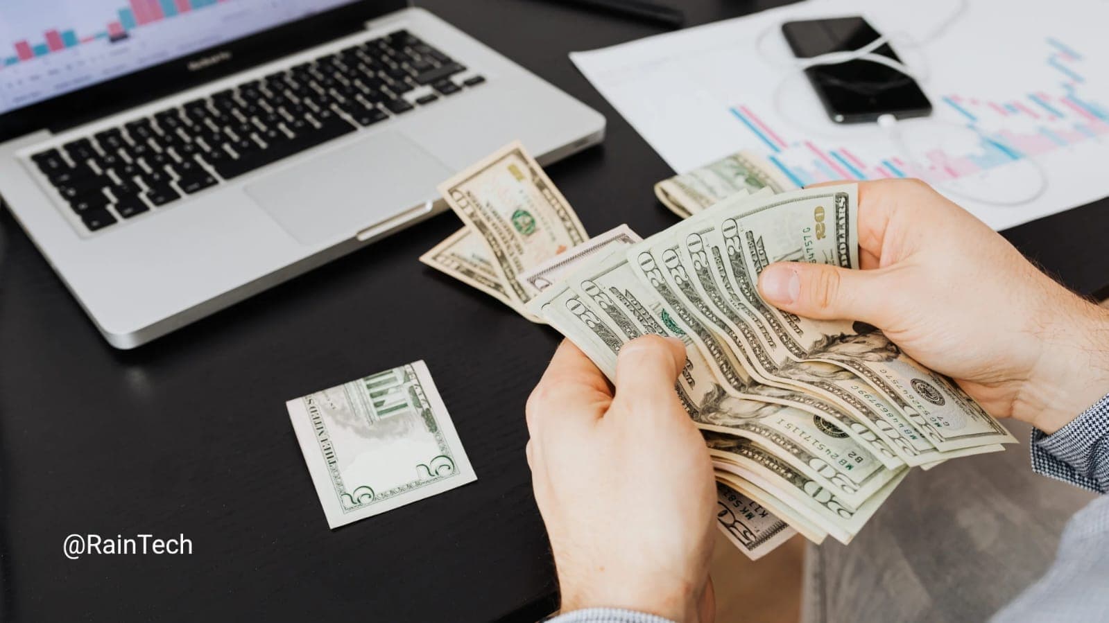 Person counting US dollar bills in front of a laptop, representing the massive $113k cost savings for startups hiring engineers through RainTech EOR.