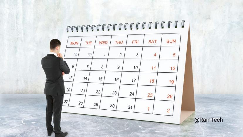 A businessman looking at a giant desk calendar showing a monthly schedule, representing corporate holiday planning and workforce management.